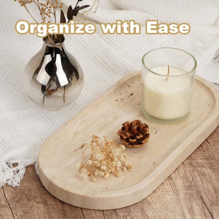 Travertine vanity tray on a wood surface with a candle, pine cone and dried flowers beside a glass vase
