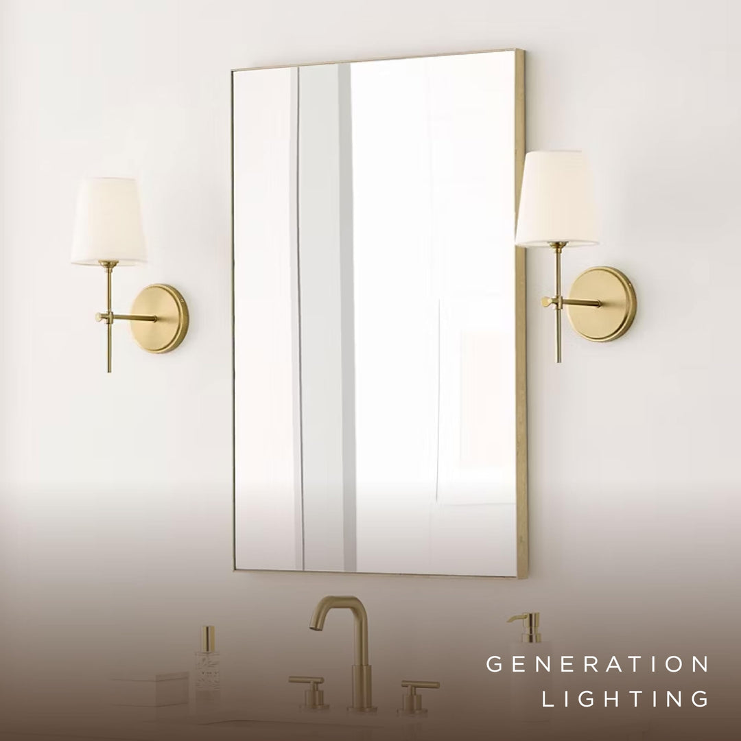 Two satin brass Baker sconces flanking a rectangular mirror above a bathroom vanity