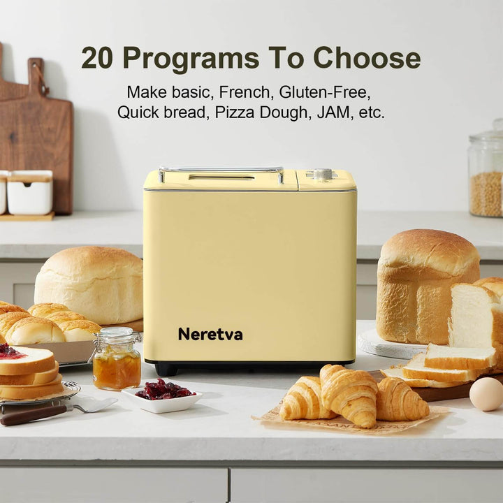 Neretva 20-in-1 Bread Maker in yellow with bread, jam, and croissants on a kitchen counter.