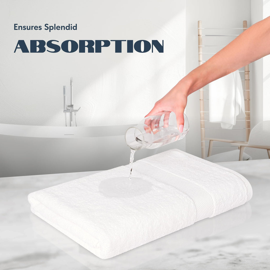 Water poured from a glass onto a folded white bath towel to show absorbency