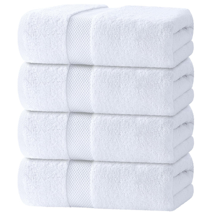 Stack of four folded white cotton bath towels with a woven border band