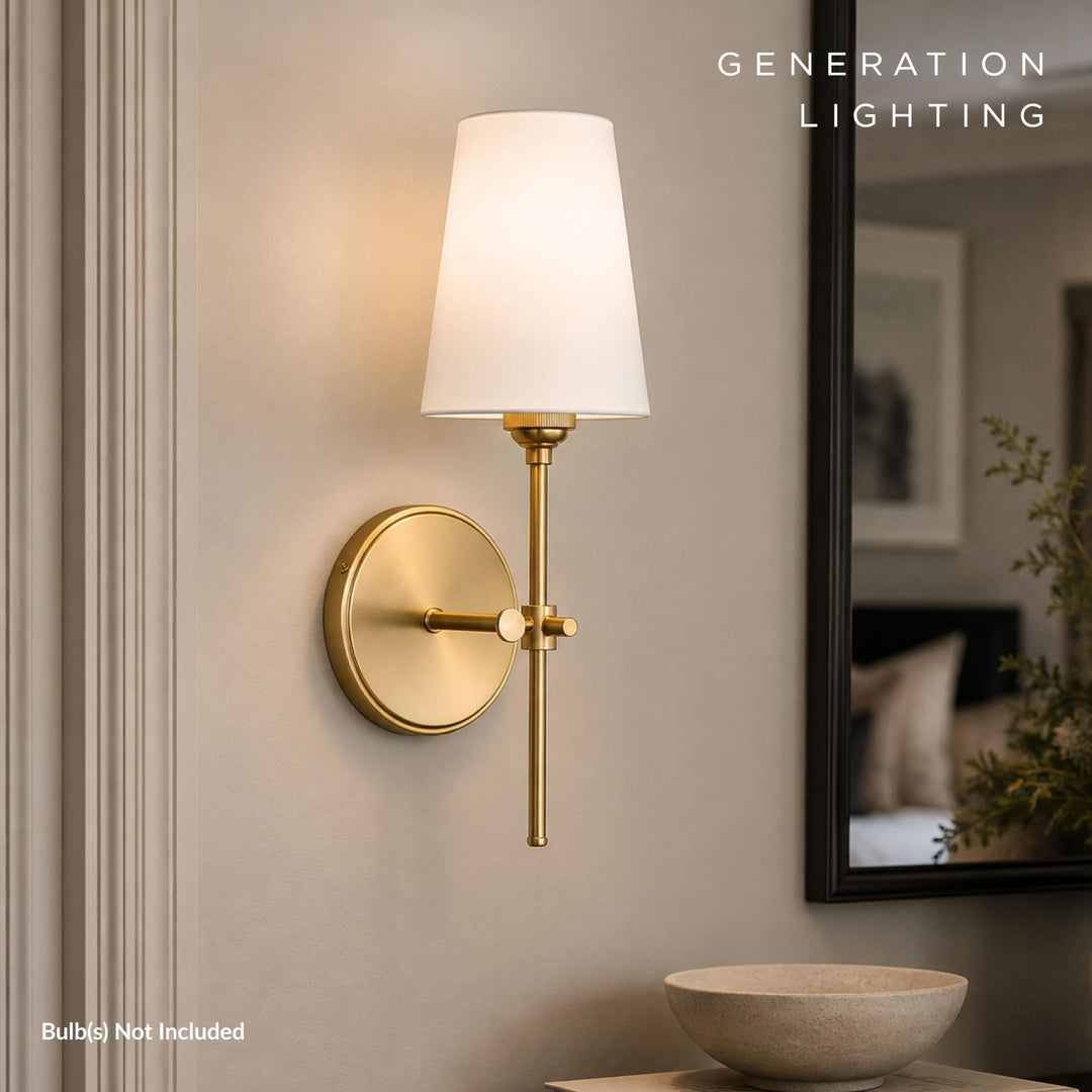 Satin brass Baker sconce lit beside a dark-framed mirror above a stone bowl