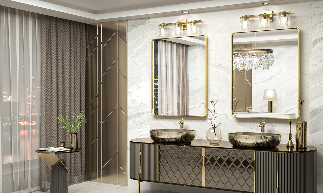 Two gold rectangular mirrors above a double vanity with vessel sinks in a marble bathroom