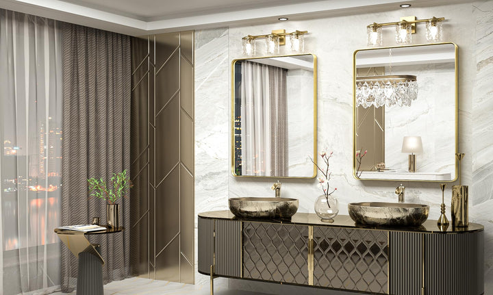 Two gold rectangular mirrors above a double vanity with vessel sinks in a marble bathroom